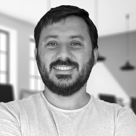 Portrait of a smiling man with beard and short hair, wearing a light shirt